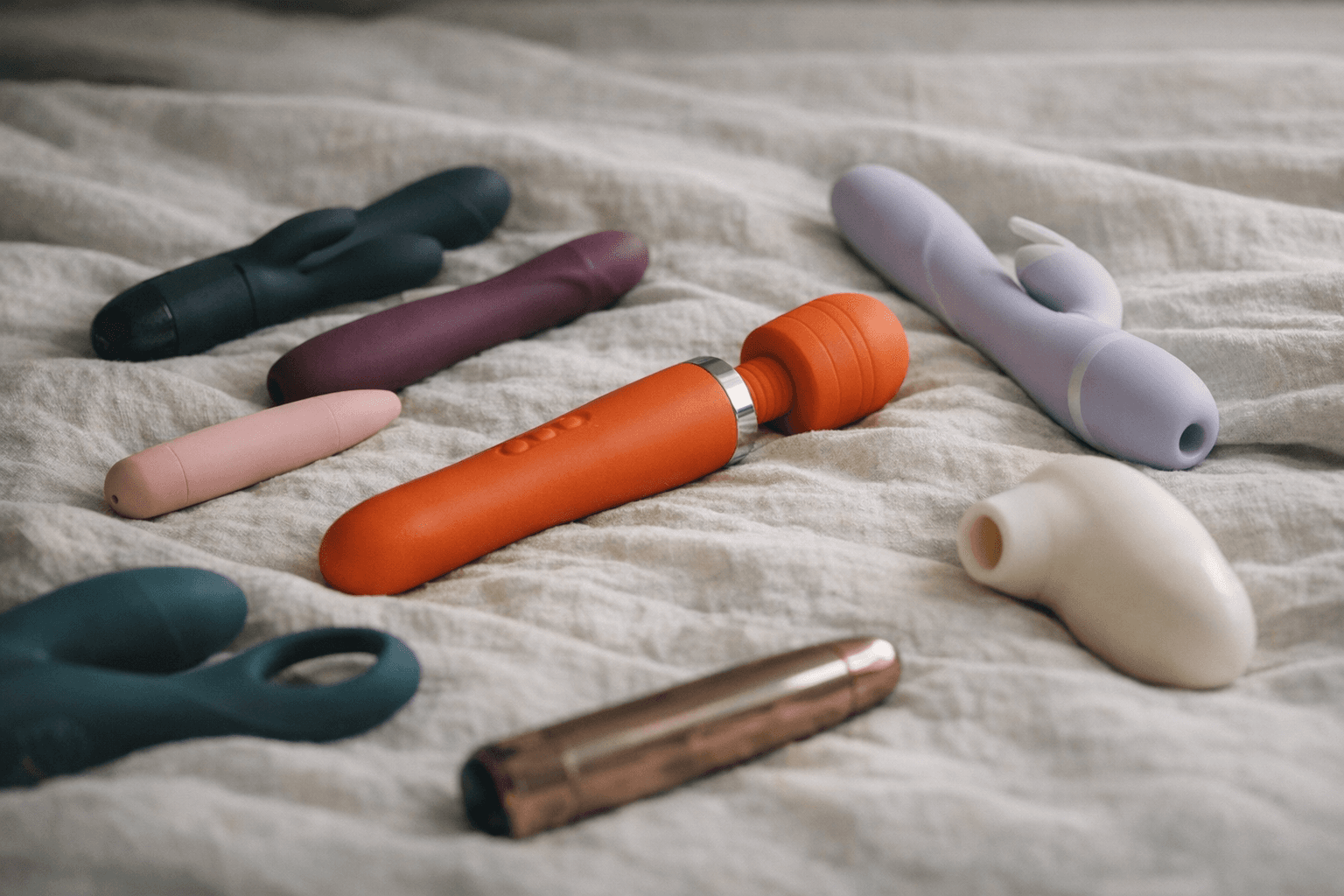 A collection of vibrators displayed on a soft fabric background.