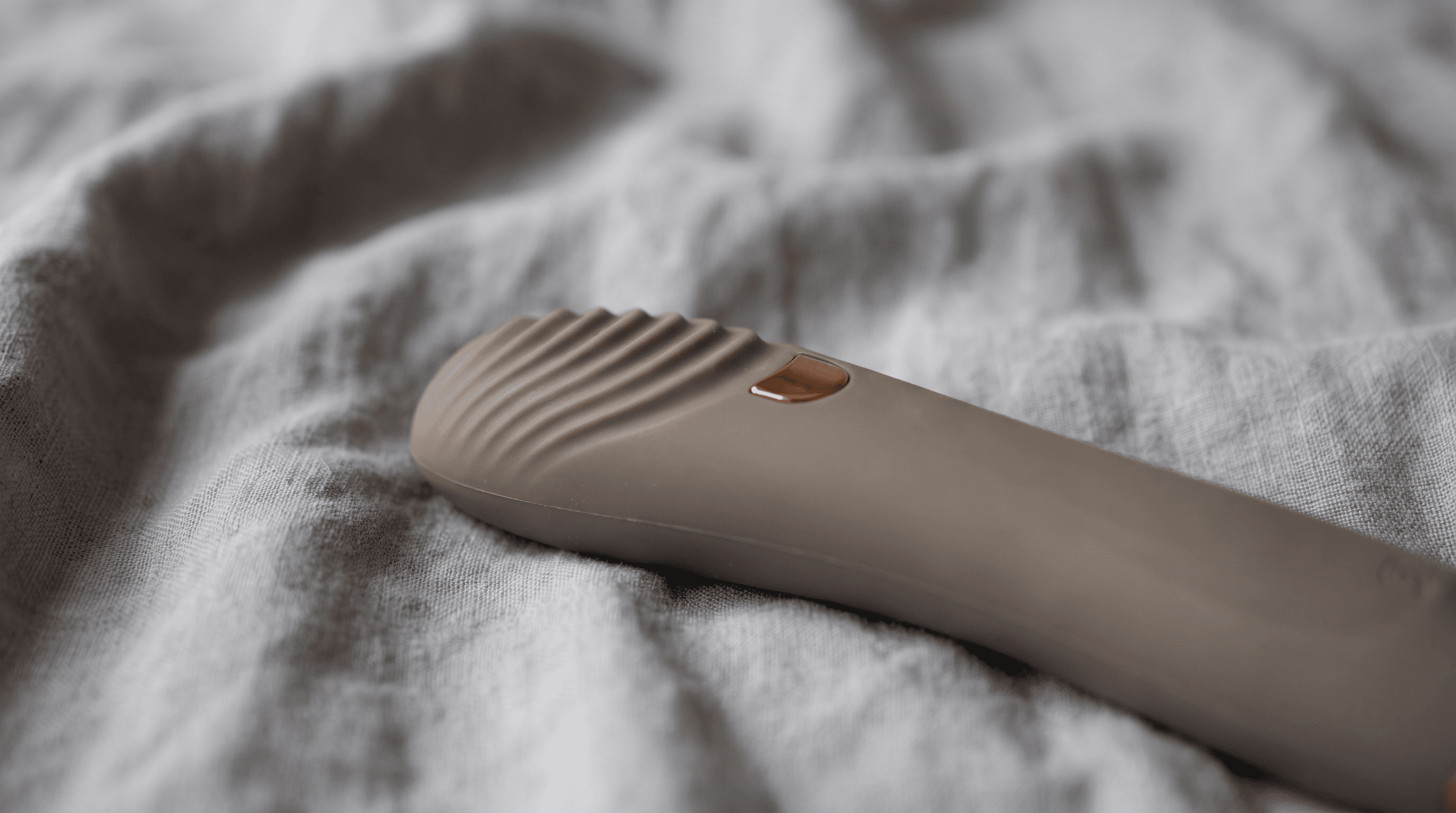 Close-up of a tongue vibrator on soft fabric